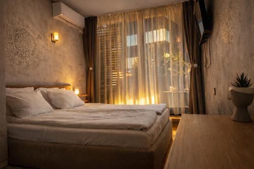 ein Schlafzimmer mit einem großen Bett und einem Fenster in der Unterkunft Silver city Paradise in Sofia