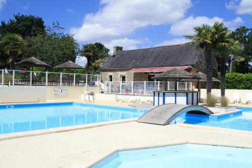 a large swimming pool with a building in the background at Camping Kerscolper - Mobil home 3 pièces 4/6 personnes + TV MAE-9591 in Fouesnant