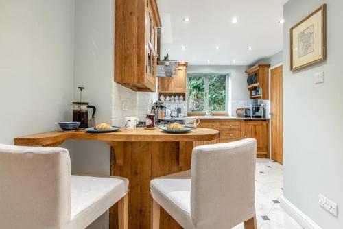 a kitchen with wooden cabinets and a counter with chairs at 3 Bed in Baslow oc-h27288 in Baslow