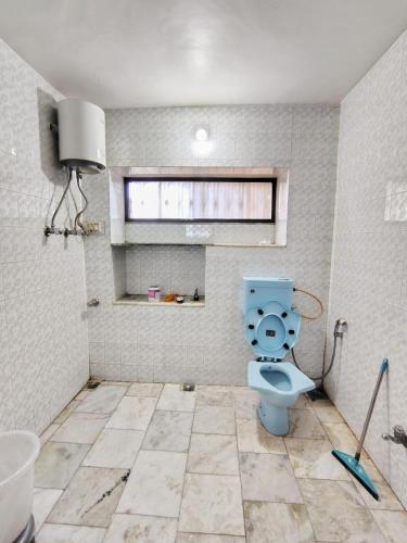 a bathroom with a blue toilet and a sink at Perth villa in Mount Ābu