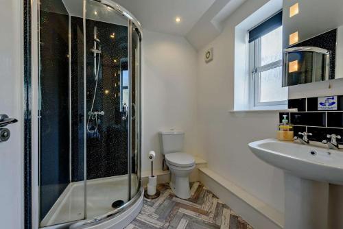 a bathroom with a shower and a toilet and a sink at 4 Bed in Tenby oc-t27576 in Tenby