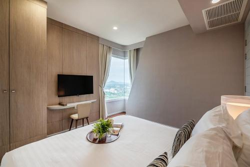 a hotel room with a bed and a tv at White Sands Beach-Beach Access-1BR-Amazing View2 in Na Jomtien