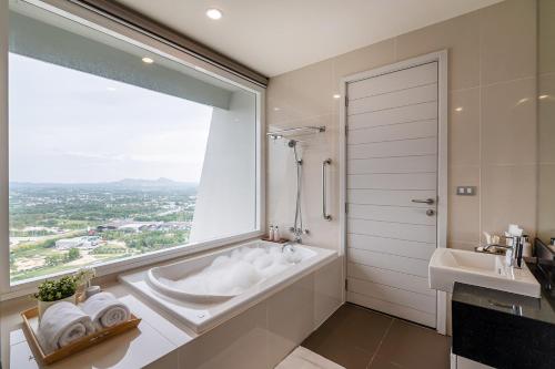 a bathroom with a tub and a sink and a window at White Sands Beach-Beach Access-1BR-Amazing View2 in Na Jomtien