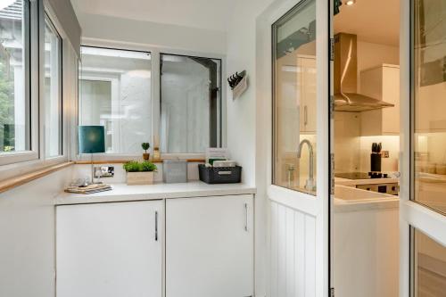 a kitchen with white cabinets and a sink and a window at 2 Bed in Chapel Stile oc-gl103 in Chapel Stile