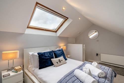 a bedroom with a bed with blue pillows and a window at 2 Bed in Chapel Stile oc-gl103 in Chapel Stile