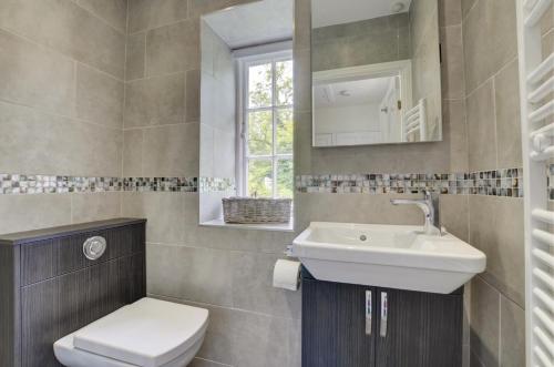 a bathroom with a sink and a toilet and a mirror at 2 Bed in Elterwater oc-gl053 in Chapel Stile