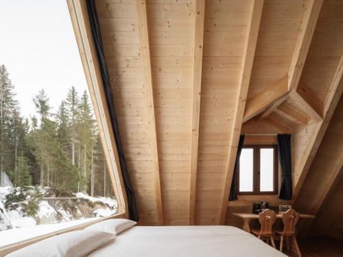 a bedroom with a large window in a cabin at Camping Cadore in Selva di Cadore