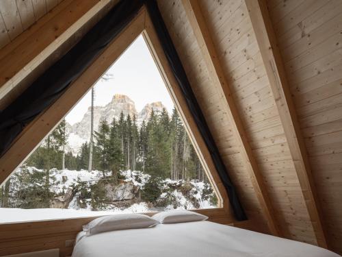 a window in a bedroom with a view of the mountains at Camping Cadore in Selva di Cadore
