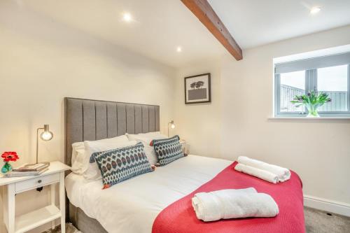a bedroom with a large bed with a red blanket at 3 Bed in Little Snoring oc-m28145 in Little Snoring