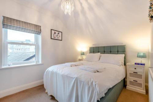 a bedroom with a bed with white sheets and a window at 2 Bed in Swanage oc-wy527 in Swanage