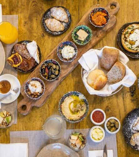 a table filled with different types of food on plates at The Efendi Hotel & Spa - Akko in Acre