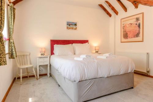 a bedroom with a large white bed with two lamps at 1 Bed in Saxmundham oc-c27420 in Farnham