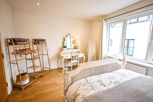 a bedroom with a bed and a desk and a window at Enbrook View in Sandgate