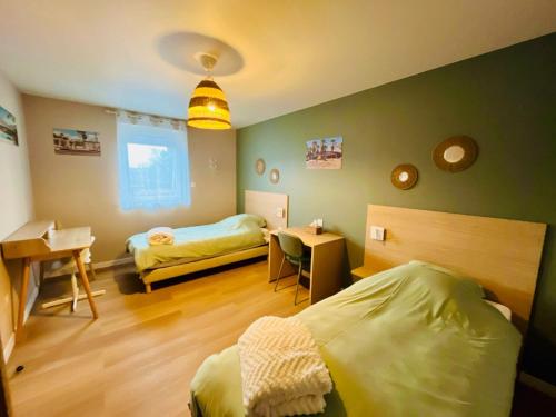 a bedroom with two beds and a desk and a window at Appartement cosy ambiance Palm Spring dans résidence avec piscine 4 pers 2 chambres in Neuf-Mesnil