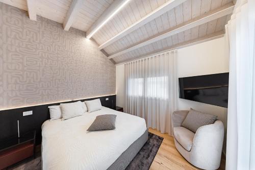 a bedroom with a bed and a chair at Luxury Villa Prestige in Sirmione