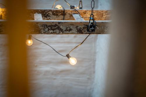 a group of lights hanging from a wall at In De Rooden Hoed in Poperinge