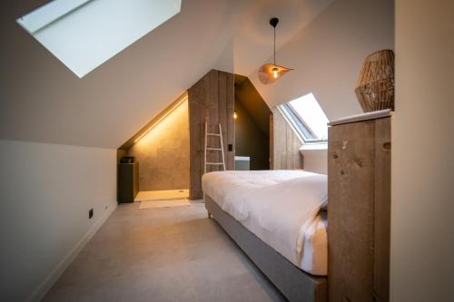 a bedroom with a large bed and a window at In De Rooden Hoed in Poperinge