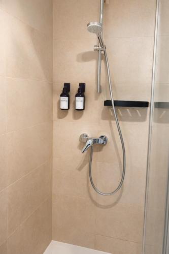 a bathroom with a shower with two bottles on the wall at Suites in Mödling in Mödling