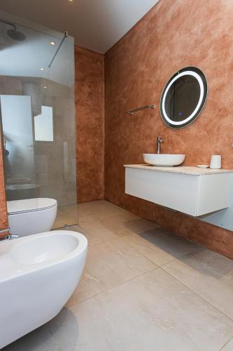 a bathroom with a sink and a toilet and a mirror at IDeal Sea View Apartment in Vlorë