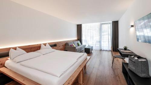 a bedroom with a large bed and a living room at die berge lifestyle-hotel Sölden in Sölden