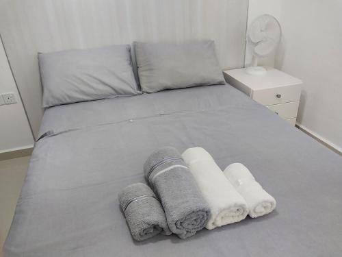 a bed with rolled towels on it in a bedroom at Pool View Apartment with Hotel Facilities in Iskele