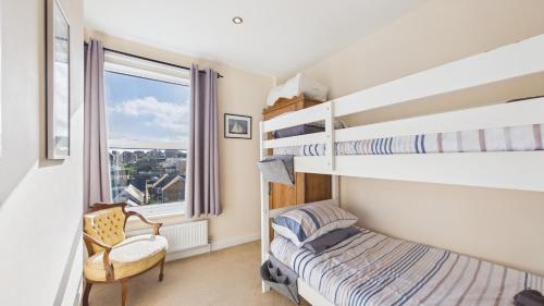 a bedroom with two bunk beds and a chair at 74 Granville Road in Cowes