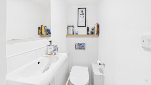 a white bathroom with a toilet and a sink at 74 Granville Road in Cowes