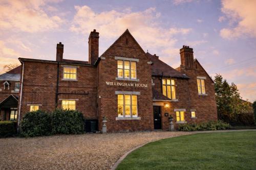 a large brick building with a sign on it at Willingham House Hotel in Willingham