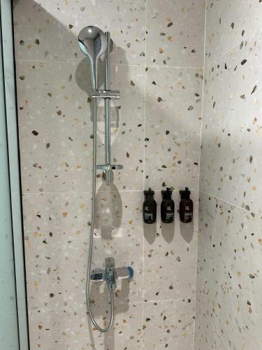 a shower in a bathroom with two bottles on the wall at 穗眠民宿SnoozeInn in Chishang