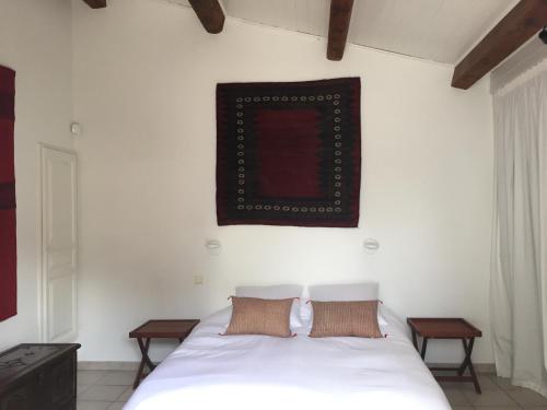 Villa Bianca في كاري-لو-رويه: غرفة نوم بها سرير أبيض وصورة على الحائط