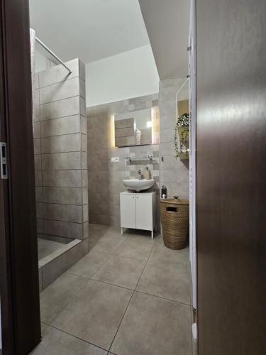a bathroom with a sink and a shower and a toilet at Jazzy Garden Apartment Komárno in Komárno