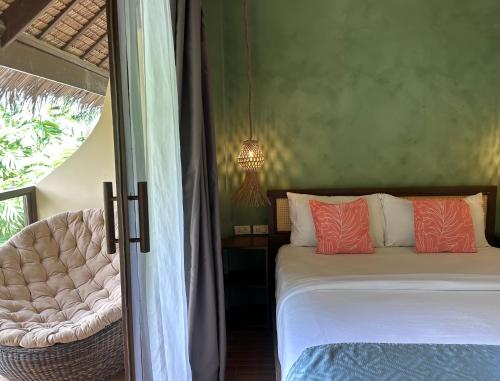 a bedroom with a bed and a chair at JungleNest Resort in General Luna