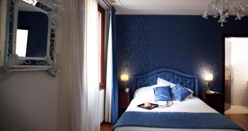 a blue bedroom with a bed with a blue wall at Hotel Ca' D'Oro - WENICE Deep Culture in Venice