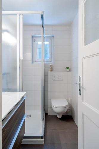 a bathroom with a toilet and a glass shower door at Chambres d'hôtes Les Vergers in Chalais