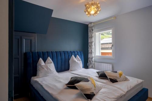 a blue bedroom with a white bed with pillows at Chambres d'hôtes Les Vergers in Chalais