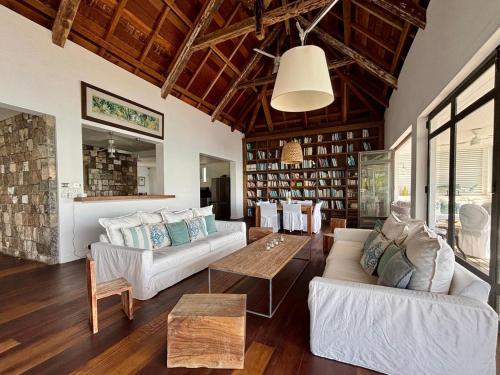 a living room with two couches and a table at Villa Canonniers - Pieds dans l'eau à Grand Baie in Pointe aux Canonniers