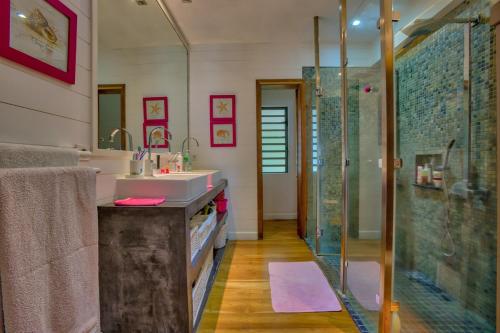 a bathroom with a sink and a glass shower at Villa Canonniers - Pieds dans l'eau à Grand Baie in Pointe aux Canonniers