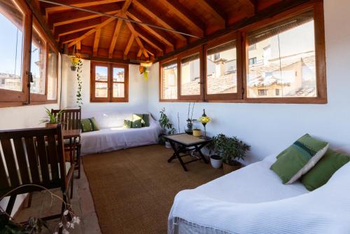 a room with two beds and a table and windows at Torreón del Vicario in Toledo
