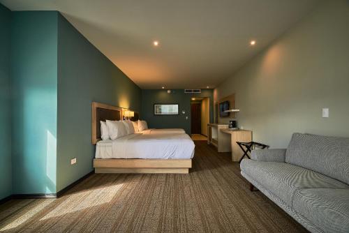 a bedroom with a bed and a couch at Wyndham Garden Saltillo in Saltillo