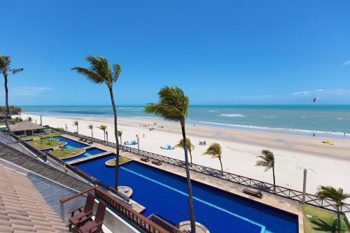 a view of a beach with palm trees and a swimming pool at Cumbuco Ocean View in Cumbuco