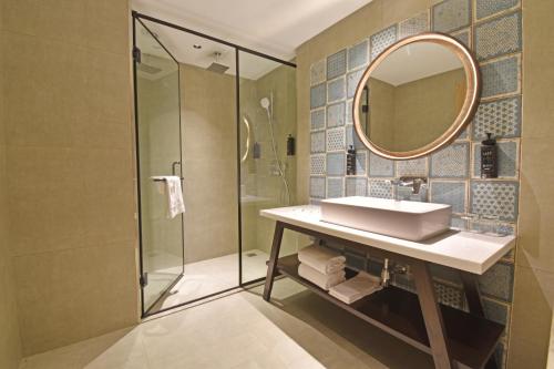 a bathroom with a sink and a mirror at Sands Point Hotel in Pondicherry