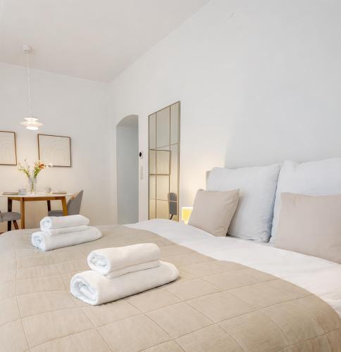 a bedroom with a large bed with white towels on it at Suites am Herzogberg in Brunn am Gebirge