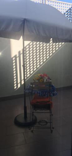 a table with an umbrella in the middle of a room at COMODIDADe in Colmenar Viejo