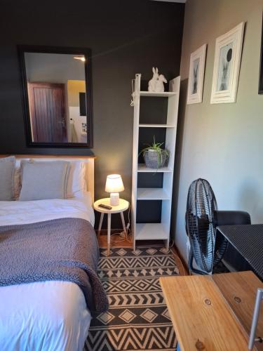 a bedroom with a bed and a mirror and a table at Cozy City Studio Escape in Centurion
