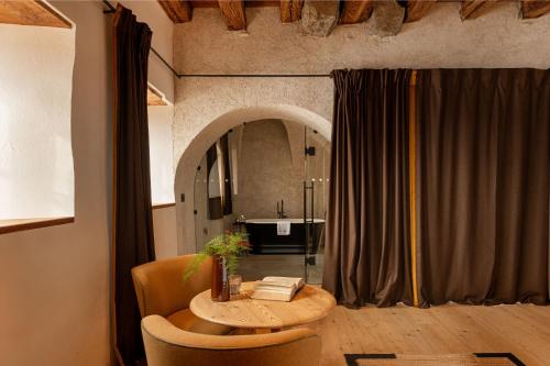 a table and chairs in a room with a mirror at Castel Badia - The Leading Hotels of the World in San Lorenzo di Sebato