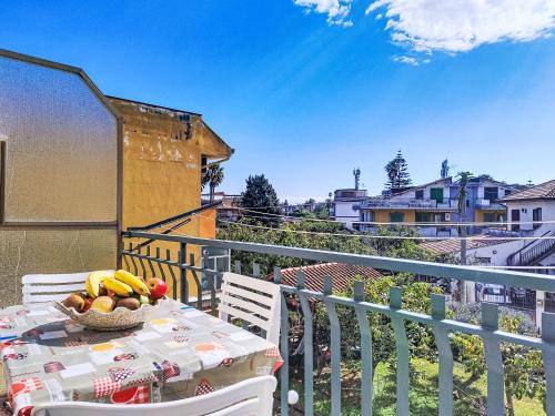 a table with a bowl of fruit on a balcony at Apartment Clara by Interhome in Fondachello