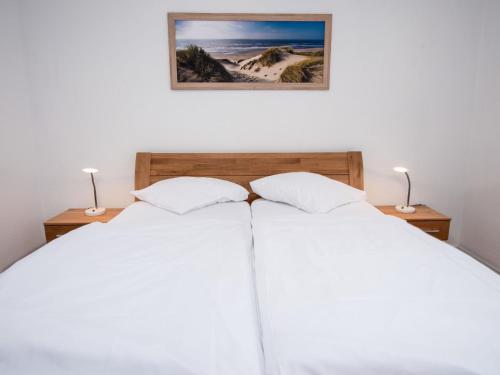 a bedroom with two white beds and two lamps at Apartment Tunnelstrasse-1 by Interhome in Norddeich