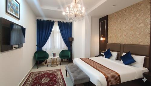 a hotel room with a large bed and a chandelier at Hotel King Plaza in Nikurān