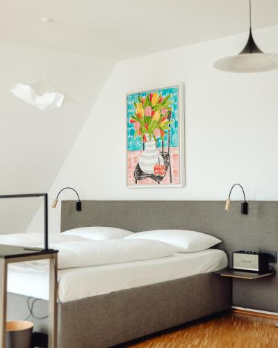 a bedroom with a bed with a painting on the wall at Lendhotel in Graz