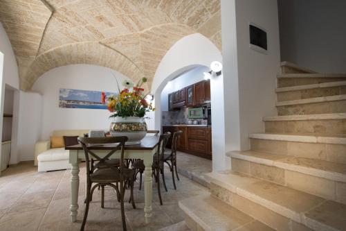una cucina e una sala da pranzo con tavolo e sedie di Casale de li Canti a Marina di Pescoluse